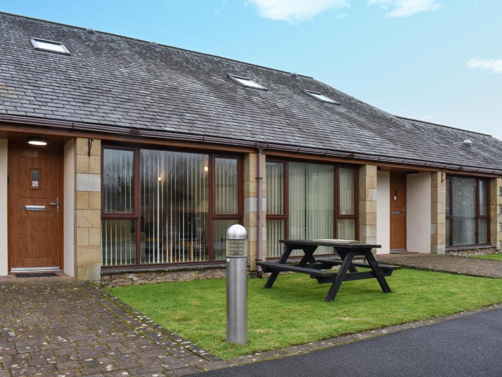 una mesa de picnic frente a un edificio en Sandpiper, en Carnforth