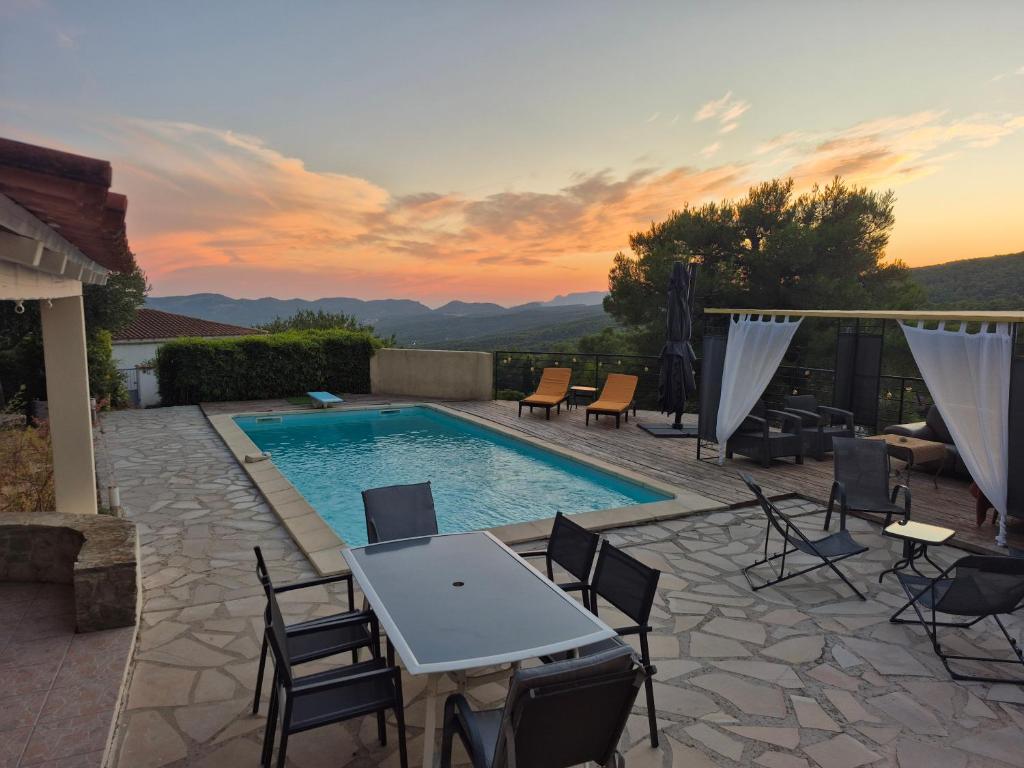 eine Terrasse mit Tisch und Stühlen und ein Swimmingpool in der Unterkunft Maison de vacances à La Ciotat Ceyreste in Ceyreste