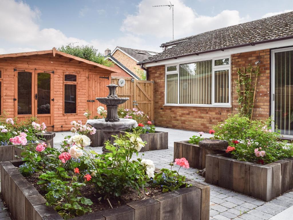 un jardín frente a una casa con una fuente en Mona's Bungalow, en Wellesbourne