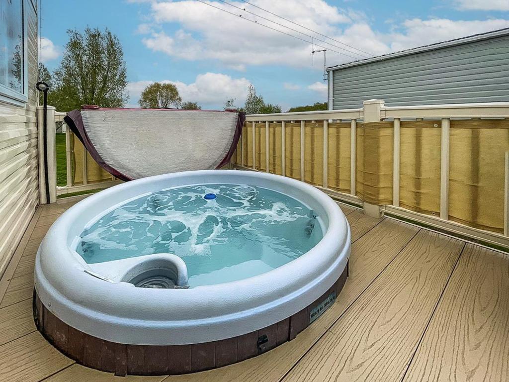 a jacuzzi tub on the deck of a house at Au Bords Du Lac - Uk49028 in Tattershall
