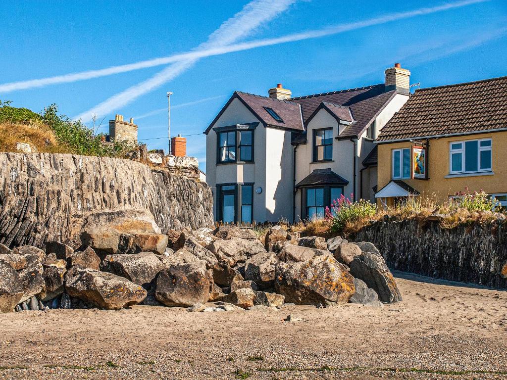 una casa en la playa con rocas delante en Parrog Point, en Newport