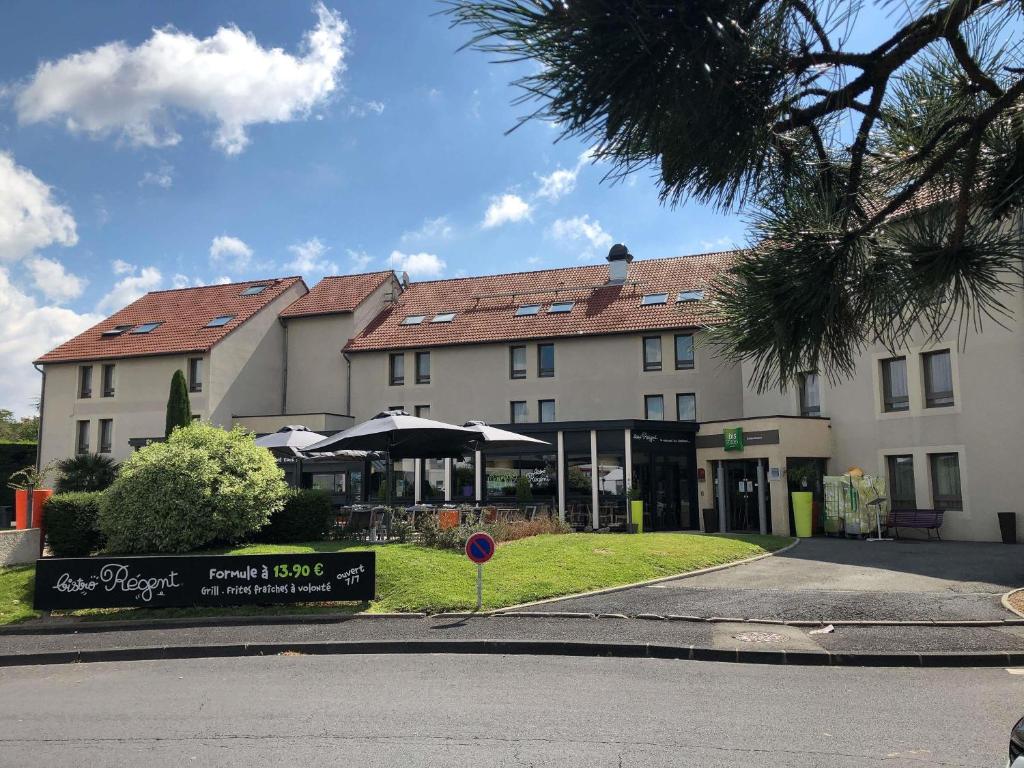 a large building with a restaurant in front of it at ibis Styles Clermont-Ferrand Aéroport in Clermont-Ferrand