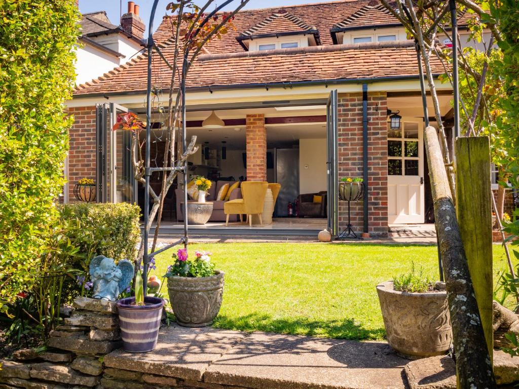 ein Haus mit Pflanzen in Töpfen in einem Hof in der Unterkunft Mallard Cottage in Winchester