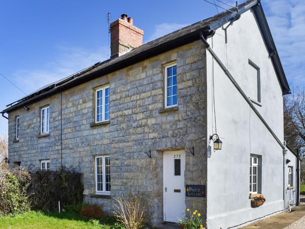 an old stone house with a chimney on top at Pickled Onion Cottage in Taunton