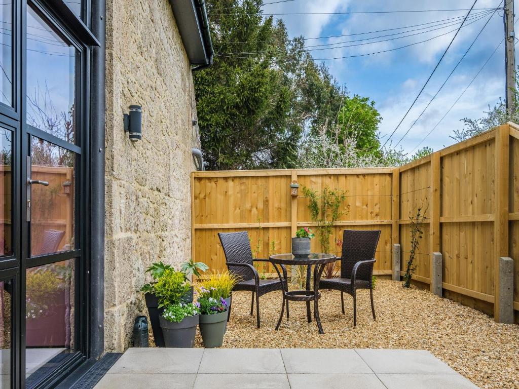 a patio with a table and chairs and a fence at The Hideaway in Yarmouth
