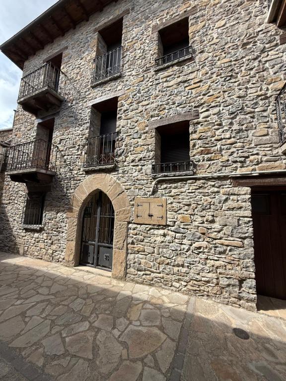 un grand bâtiment en pierre avec des fenêtres et une porte dans l'établissement Casa Angel, à Santa Cilia de Jaca