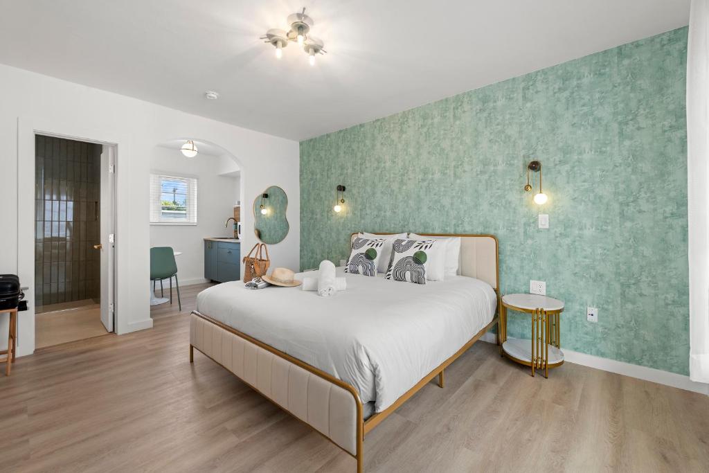 Un dormitorio con una cama y una pared verde. en Bianco Hotel, en Miami