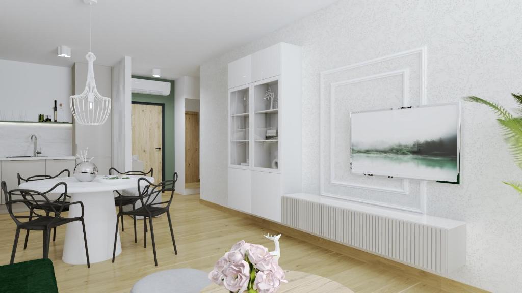ein Wohnzimmer mit einem Tisch und einem TV an der Wand in der Unterkunft Apartament Margaret in Oppeln
