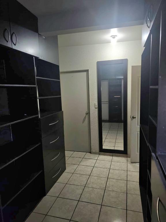 a bathroom with black cabinets and a mirror and a door at Private, centrally located, spacious and comfortable residence in Hermosillo