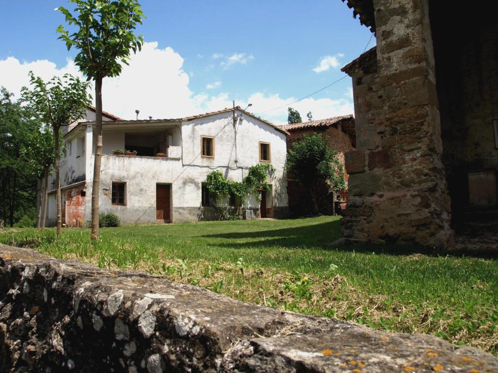 una casa vieja en un patio con una pared de piedra en Ca la iaia Veva, en Sant Joan les Fonts