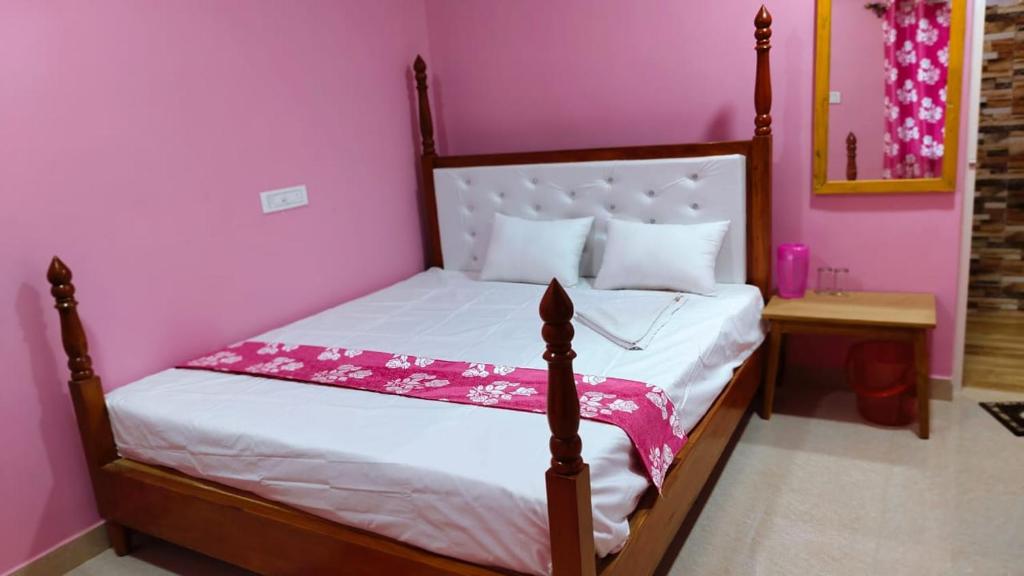 - une chambre avec un lit dans une chambre rose dans l'établissement Hotel ruposhi bangla, à Purbbadulki