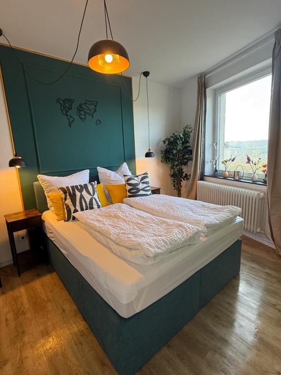 ブレーマーハーフェンにあるZentrales Apartment Yachthafen free parkingの緑のヘッドボードが付いた大きなベッドのある寝室