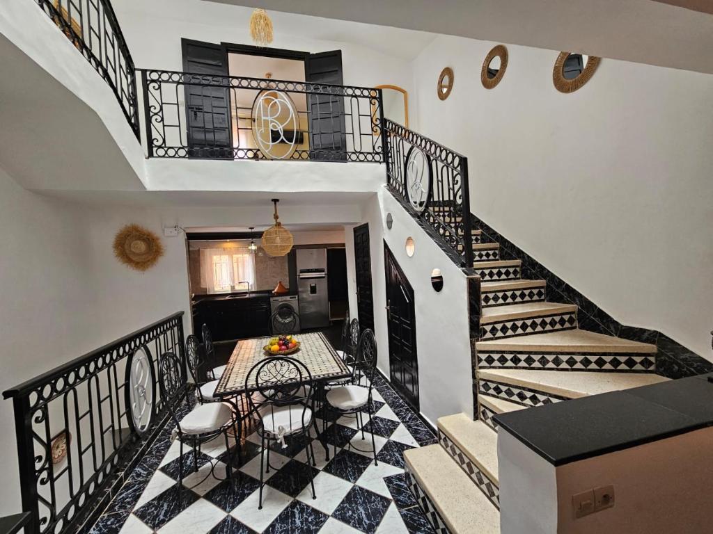a room with a staircase with a table and chairs at Riad Latifa in Marrakech