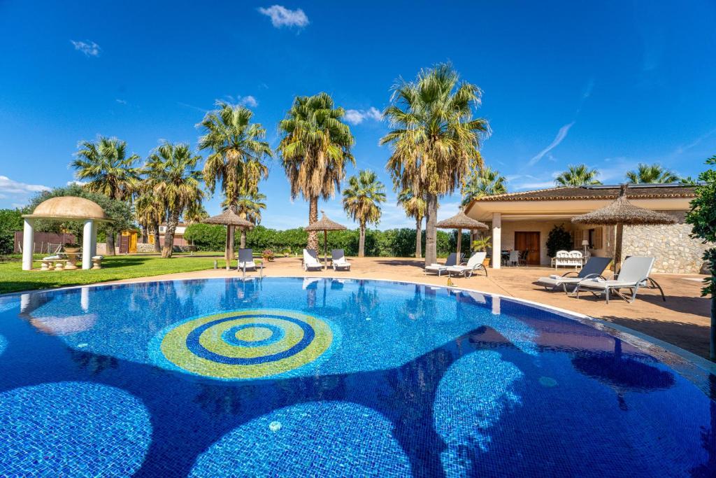a swimming pool in a villa with palm trees at Ideal Property Mallorca - Son Manyo 223 in Sa Pobla