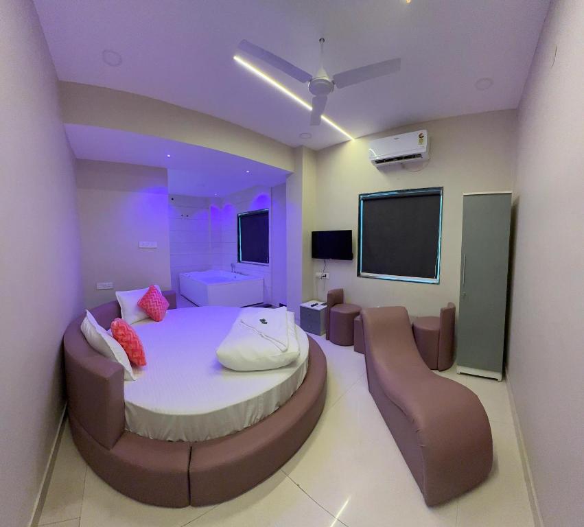 Camera con letto, sedie e TV a schermo piatto. di Hotel Elite Stay - Mahalunge Pune a Pune
