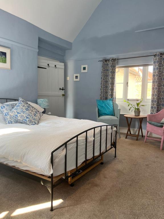 een slaapkamer met een bed, een stoel en een tafel bij Flemish House in Beccles