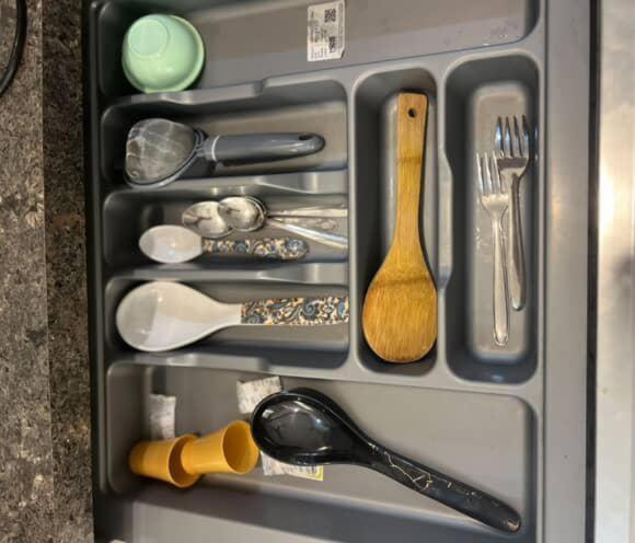 a drawer with utensils in a refrigerator at Modern peaceful private property in Noida