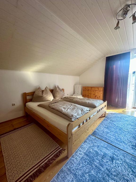 a bedroom with a large bed with a blue rug at Apartment Roßleithen in Bahnhof Roßleithen
