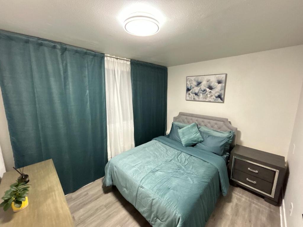 Un dormitorio con una cama verde y una mesa. en Guest apartments The Comfy Nest, en Federal Way