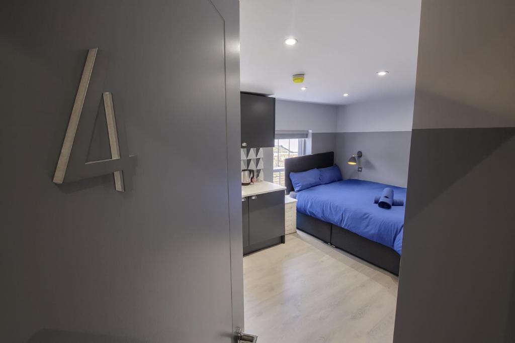 a bedroom with a blue bed and a desk at 343 Luxury in Caledonian Central London in London