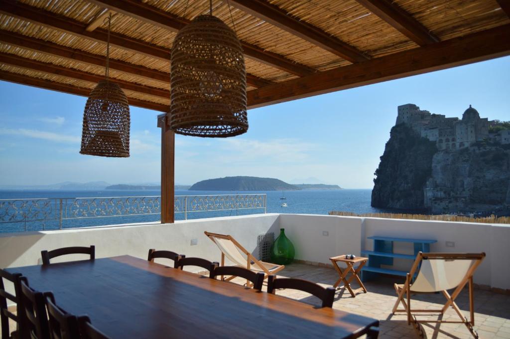 a dining room with a table and a view of the ocean at Terrazza Aragonese in Ischia Town