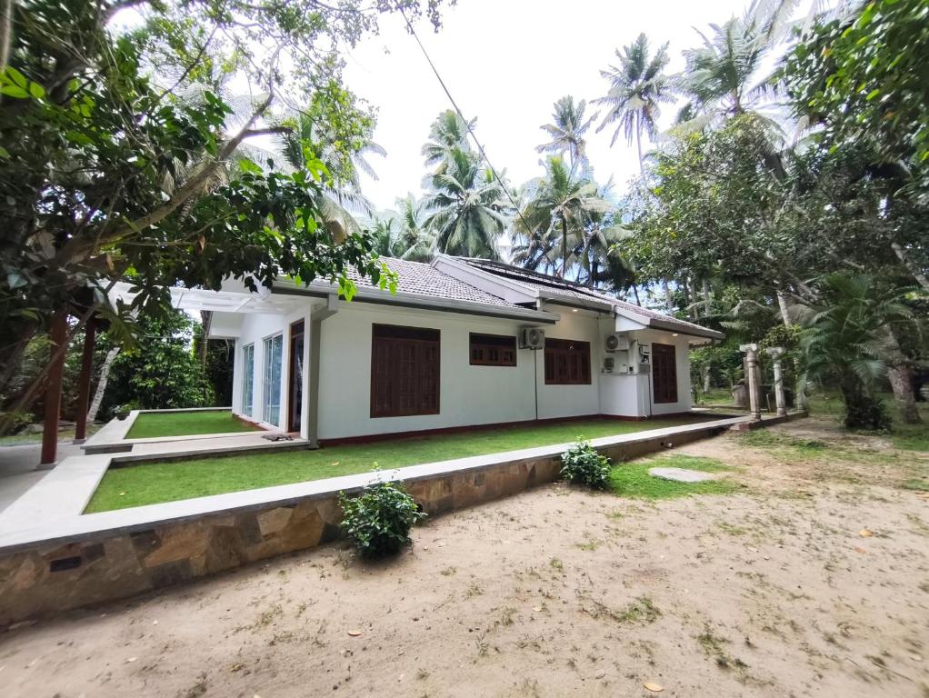 une maison au milieu d'une cour dans l'établissement Priyanwada Lake Cottage, à Nikawatawana