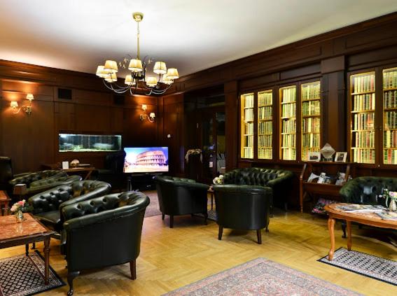 un salon avec des fauteuils verts et une télévision dans l'établissement Business hotel - Grand Hotel Residence Piešťany, à Piešťany