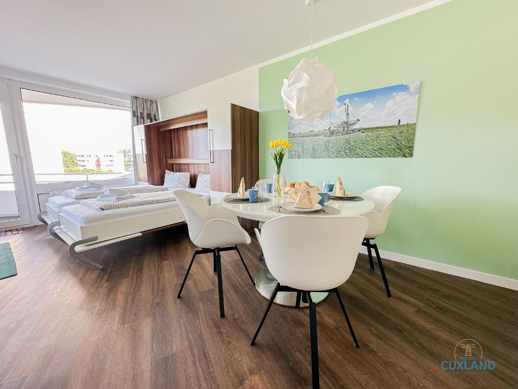 1 dormitorio con mesa, sillas y 1 cama en Watt n Blick 220, en Döse