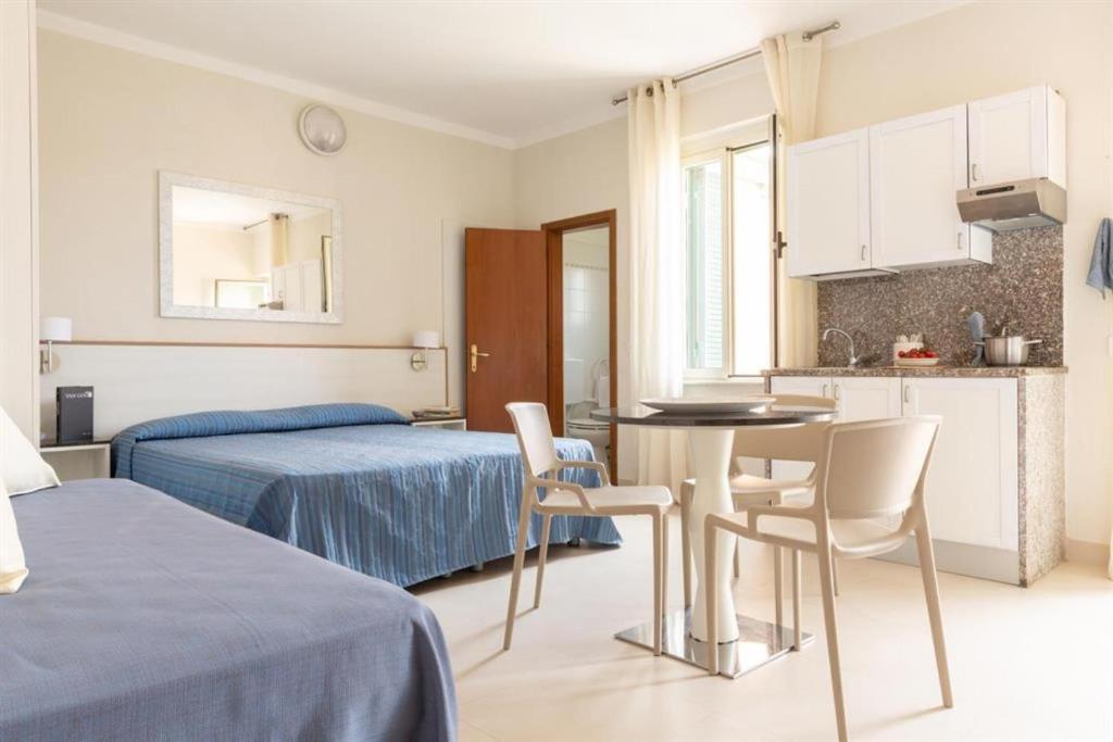 a bedroom with a bed and a table and chairs at Happy Sea Home - monolocale sul mare in Albinia