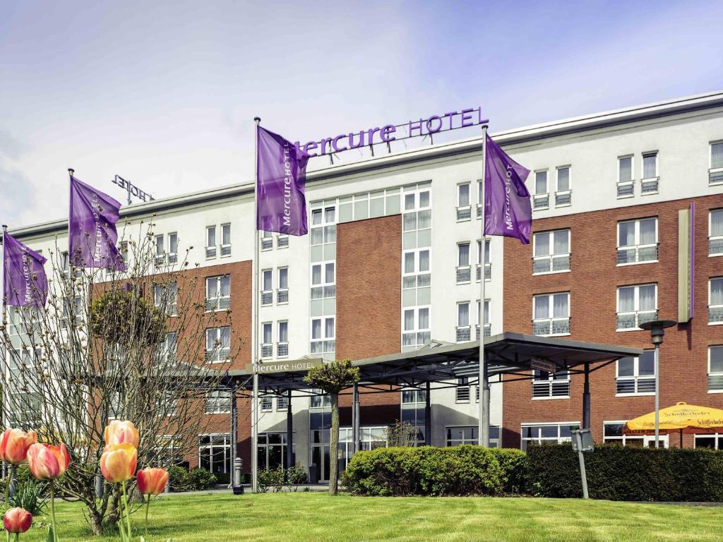 a hotel with purple flags in front of a building at Mercure Kamen Unna in Kamen
