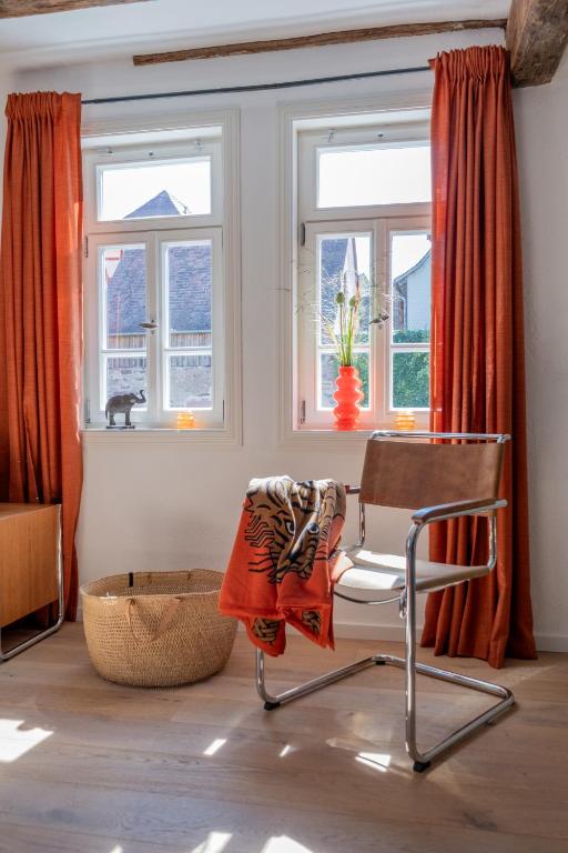 a chair sitting in a room with windows at Zur Traube - grün in Erbach