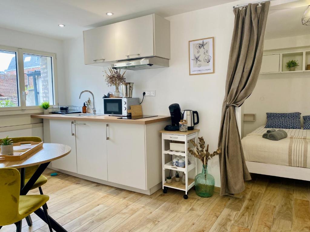 a kitchen and living room with a bed and a table at Le Nid Marin in Ault