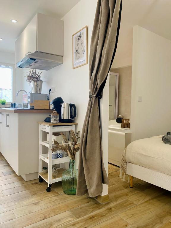 a room with a kitchen and a bed and a table at Le Nid Marin in Ault