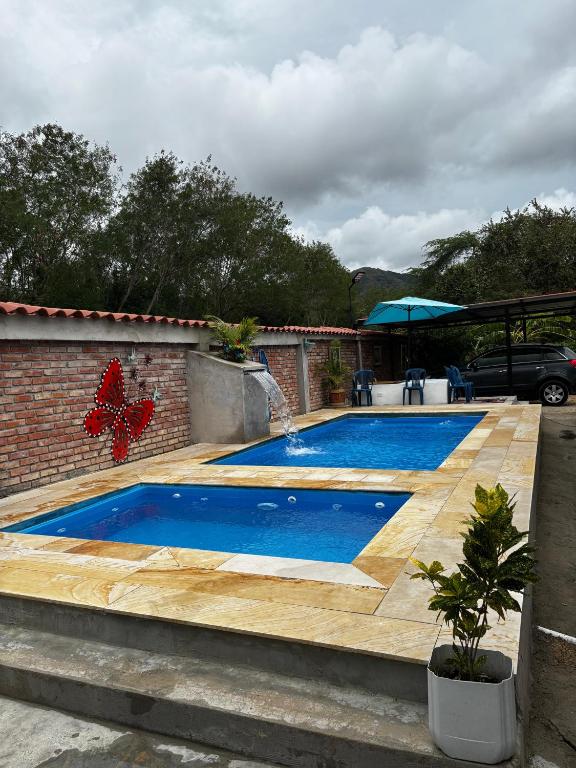 a pool with a wooden deck with a butterfly on it at Finca vacacional la manuelita in Girardot