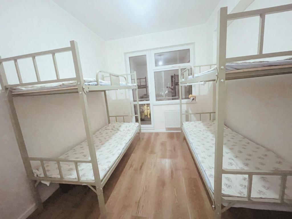 Habitación con 3 literas y suelo de madera. en Sunrise Guesthouse UB, en Ulán Bator