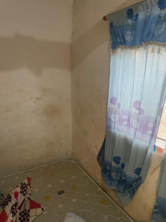 a corner of a room with a curtain on a window at Paasam Gh in Takoradi
