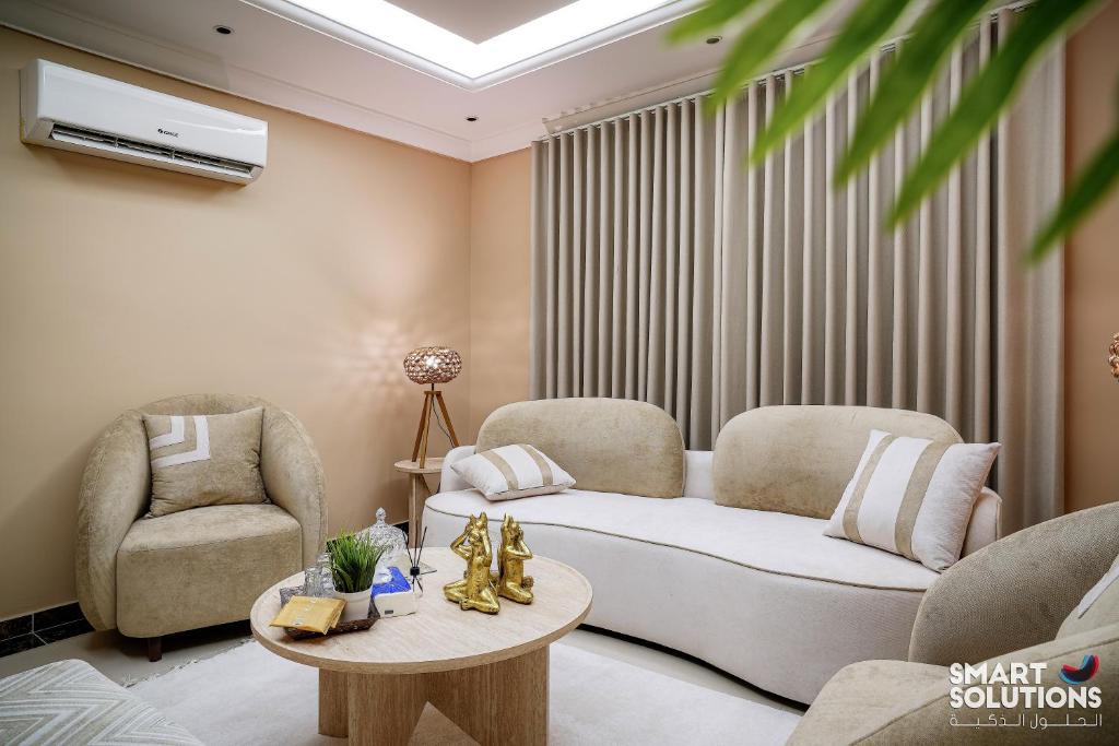 a living room with a couch and two chairs and a table at Twleen luxury 408 in Jeddah