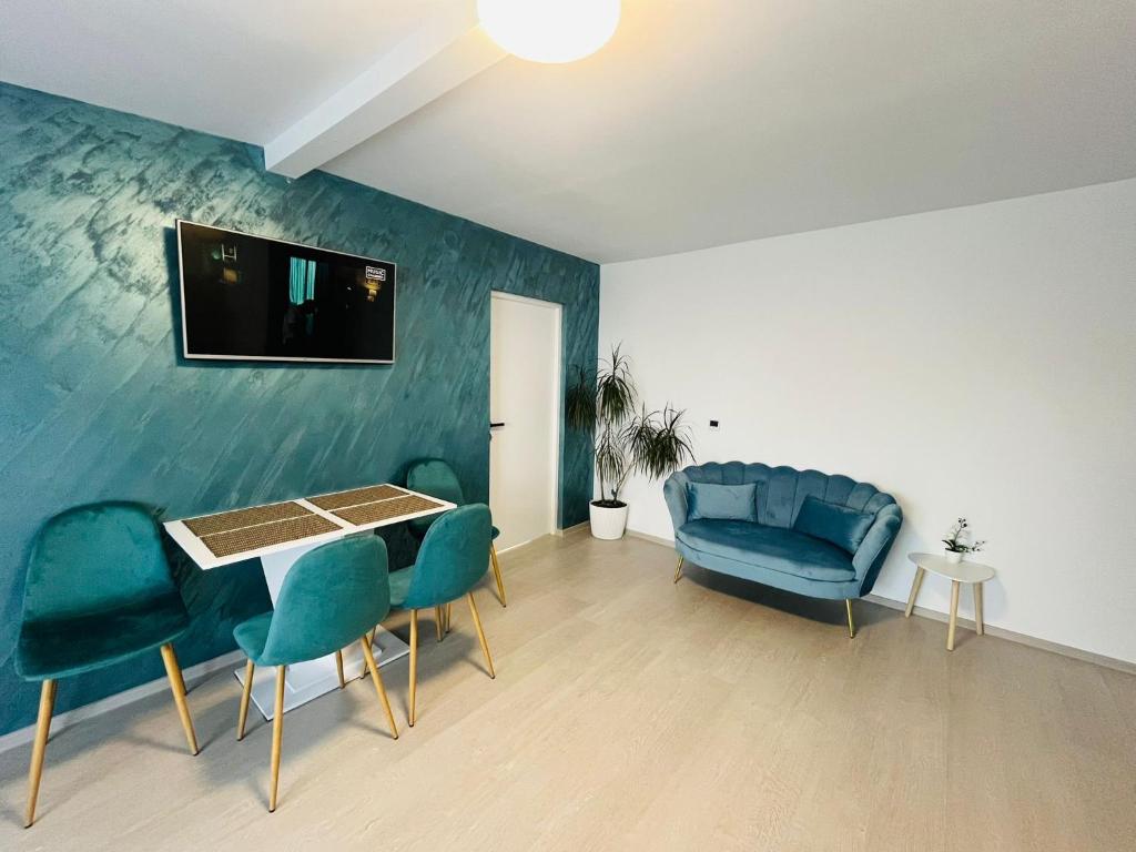a living room with blue chairs and a table at Antonia home in Târgu-Mureş
