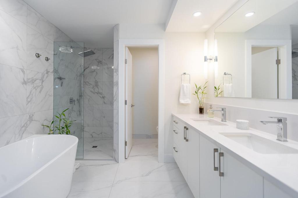 Nanoose BayにあるHigh Tide Suite - New Bright Oceanfront Escape with Spa-like Bathの洗面台2つとシャワー付きの白いバスルーム