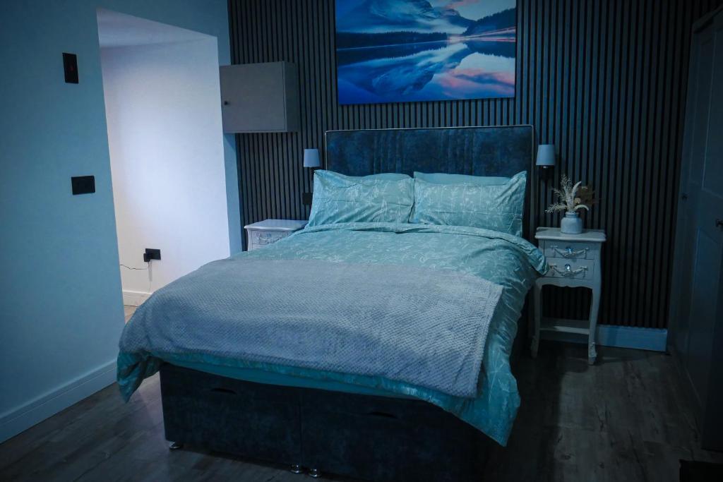 a bedroom with a bed with a blue comforter at Northern apartments in Wincobank