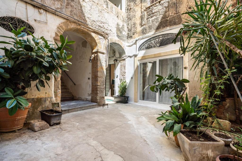 a courtyard of a building with potted plants at Loft San Basilio in Palermo
