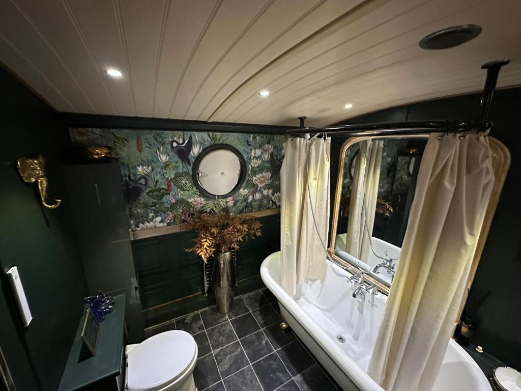 a bathroom with a tub and a toilet and a sink at Selene Unique Luxury Houseboat Experience in Chertsey