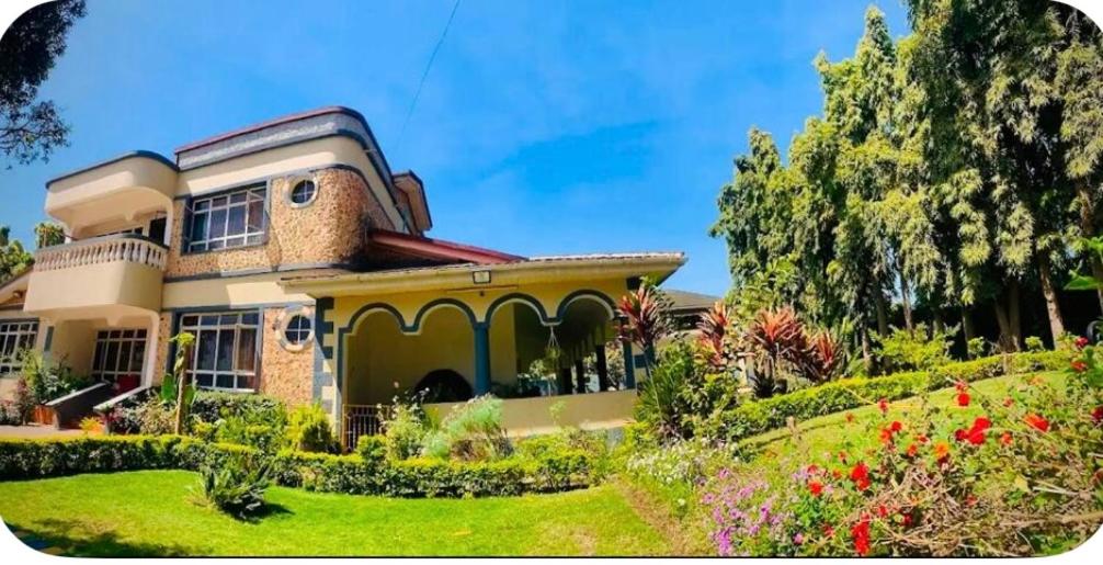 a house with a garden in front of it at Giving Hands Homestay in Arusha