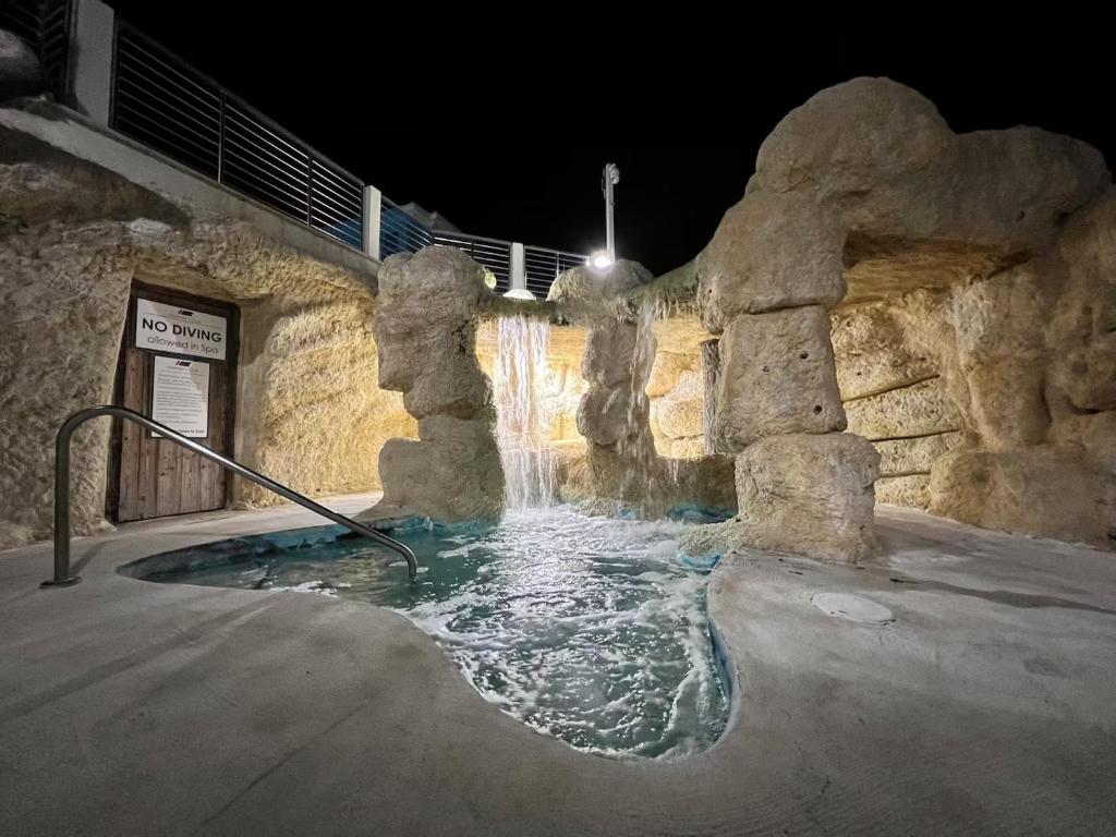 a water fountain in a stone building at night at Keys Escape 4 Stories, Rooftop Views & 3 Suites in Key Largo