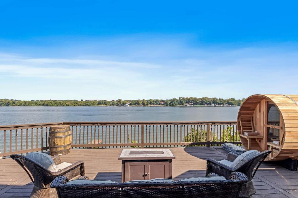 a deck with chairs and a table with a view of the water at New Renovated 5BD Home with Hot Tub Sauna & Game Rm in Prospect