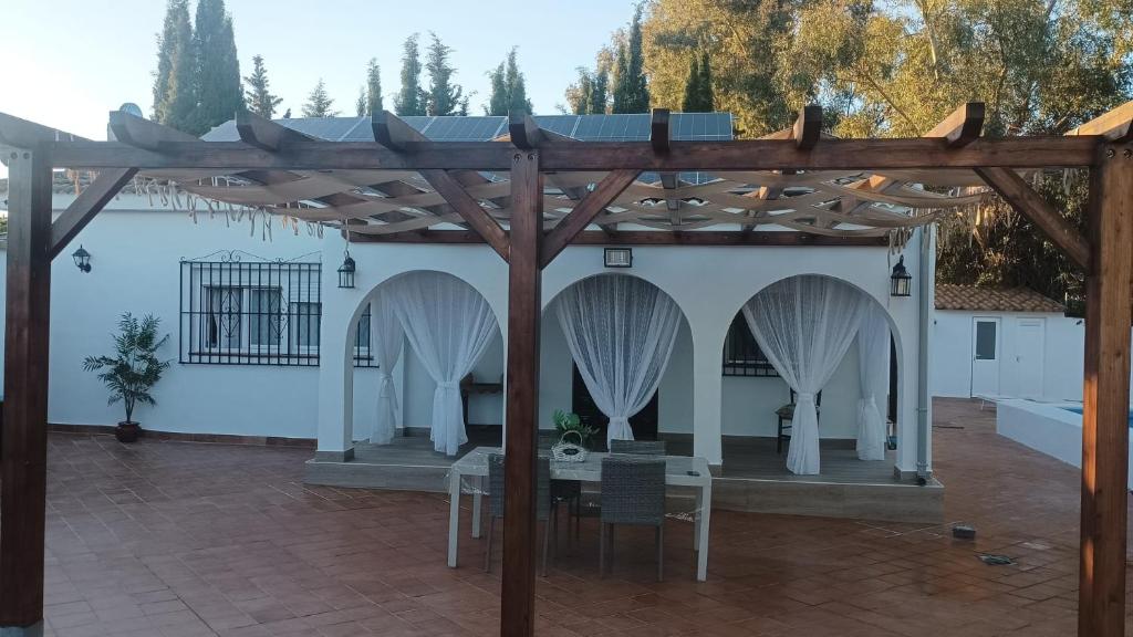 eine Pergola mit einem Tisch und Stühlen darunter in der Unterkunft Alojamiento Rural Paraiso Pozuela in Jaén