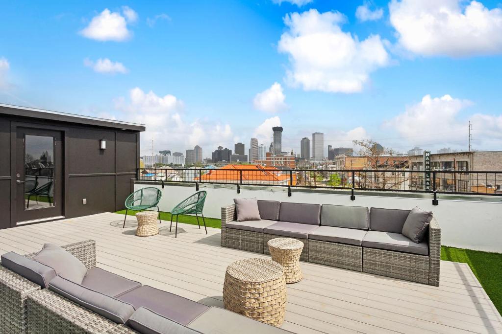 a patio with a couch and chairs on a roof at Venus Rooftop Villa in New Orleans