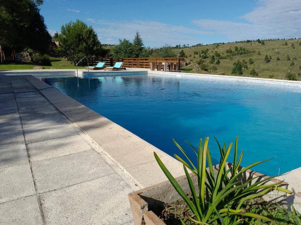 a swimming pool with blue water in a yard at Aires Colina in Villa Berna