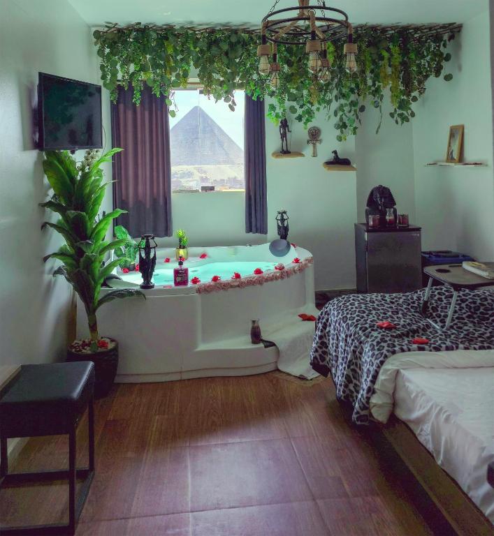 开罗Pyramids ICON 4 & 5的一间带浴缸的房间，窗户上有一个金字塔