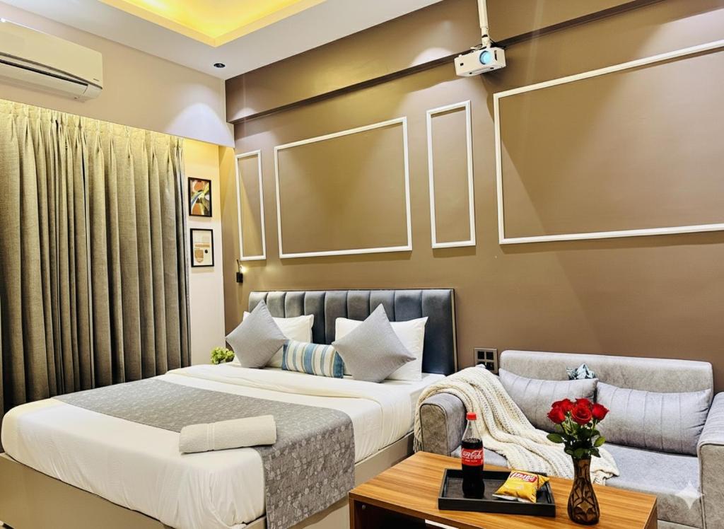 a bedroom with a bed and a couch at Private Cinema Apartment By Buddies Home in Greater Noida